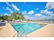 Community pool with lake view and lounge chairs at 6841 74Th Street E Cir, Bradenton, FL 34203