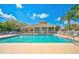 Community pool with surrounding lounge chairs and clubhouse in background at 6841 74Th Street E Cir, Bradenton, FL 34203