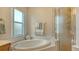 Bathroom features soaking tub, walk-in shower, and window at 6920 74Th Street E Cir, Bradenton, FL 34203