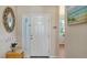 Bright and airy entryway with a mirror and orchid plant at 6920 74Th Street E Cir, Bradenton, FL 34203