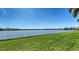 Scenic view of a lake with lush green grass and houses in the background at 6920 74Th Street E Cir, Bradenton, FL 34203