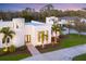 Elevated view of a modern white house with a circular tower at dusk at 6939 Bee Ridge Rd, Sarasota, FL 34241