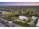 Aerial view of a contemporary white house with a circular tower and detached garage at 6939 Bee Ridge Rd, Sarasota, FL 34241