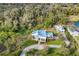 An aerial view showcasing a luxurious white house nestled on a spacious lot with lush greenery at 6939 Bee Ridge Rd, Sarasota, FL 34241