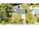 Aerial shot of a blue house with a long driveway, backyard, and a pond on the property at 712 N Elm St, Englewood, FL 34223