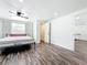 Bedroom with wood-look floors, white walls and trim, and natural light from a window at 712 N Elm St, Englewood, FL 34223