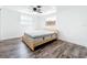 Bright bedroom with wood-look floors, white trim, and natural light from two windows at 712 N Elm St, Englewood, FL 34223