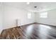 Bright bedroom featuring wood-look floors, white walls, and natural light from two windows at 712 N Elm St, Englewood, FL 34223