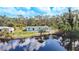 This exterior shows the house with a pond in the backyard, complemented by a blue sky at 712 N Elm St, Englewood, FL 34223