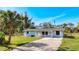 Inviting single-story home featuring a well-maintained lawn, a gravel driveway, and a cozy front porch at 712 N Elm St, Englewood, FL 34223