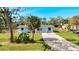 Charming single-story home with a gravel driveway, lush lawn, and a welcoming porch at 712 N Elm St, Englewood, FL 34223