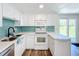 Nicely updated kitchen with white cabinetry, stylish backsplash, and stainless steel sink at 712 N Elm St, Englewood, FL 34223