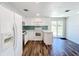 Well-lit kitchen featuring white cabinetry, modern appliances, and a door leading outside at 712 N Elm St, Englewood, FL 34223