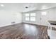 Bright living room with modern flooring, ample natural light from the large window, and white painted walls at 712 N Elm St, Englewood, FL 34223