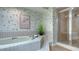 Bathroom with a bathtub, shower, and floral wallpaper at 7610 Fairway Woods Dr # 205, Sarasota, FL 34238