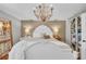 Elegant main bedroom with a decorative chandelier, white bed frame, and a view of the closet at 7820 Seville Cir, Bradenton, FL 34209