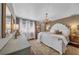 Luxurious main bedroom with a chandelier, white furniture, and natural light from the windows at 7820 Seville Cir, Bradenton, FL 34209