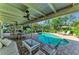 Relaxing pool patio features ample seating, a brick fireplace, and views of the refreshing pool at 7820 Seville Cir, Bradenton, FL 34209