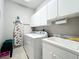 Laundry room with washer, dryer, cabinets, and utility sink at 9367 Hawk Nest Ln, North Port, FL 34287