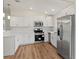 Modern kitchen with white cabinets, stainless steel appliances, and quartz countertops at 939 Cronley Pl, Sarasota, FL 34237