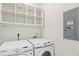 Laundry room with Samsung washer and dryer and overhead shelving at 939 Cronley Pl, Sarasota, FL 34237