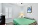 Bright bedroom featuring a green comforter and plantation shutters at 1115 116Th E St, Bradenton, FL 34212
