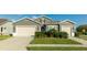 Two-story house with gray siding, beige garage doors, and manicured landscaping at 1115 116Th E St, Bradenton, FL 34212
