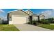 Two-story house with gray siding, beige garage door, and neatly landscaped yard at 1115 116Th E St, Bradenton, FL 34212