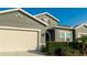 Gray house with beige garage door and lush green landscaping at 1115 116Th E St, Bradenton, FL 34212