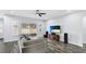 Living room with wood-look tile floors, large TV, and sliding glass doors to backyard at 1115 116Th E St, Bradenton, FL 34212