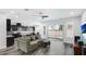 Open concept living space with gray couch, kitchen view, and sliding glass doors at 1115 116Th E St, Bradenton, FL 34212
