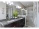 Modern bathroom with double sinks, granite countertops, and a glass-enclosed shower at 11343 Spring Gate Trl, Bradenton, FL 34211