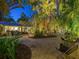 Tropical courtyard with brick paving, lounge seating, and outdoor lighting at 1330 N Lockwood Ridge Rd, Sarasota, FL 34237