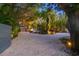 Gravel driveway with lighting, tropical landscaping, and parking for multiple cars at 1330 N Lockwood Ridge Rd, Sarasota, FL 34237