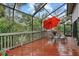 Relaxing deck with red umbrella, chairs, and lush greenery at 1444 Landings Cir # 72, Sarasota, FL 34231