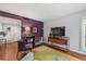 Living area with hardwood floors, purple accent wall, and flat-screen TV at 1444 Landings Cir # 72, Sarasota, FL 34231