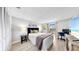 Bright bedroom features a walkout balcony, desk, and calming decor at 14820 Rue De Bayonne # 308, Clearwater, FL 33762