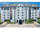 Beautiful condo building with manicured landscaping, covered entrance, and a neutral color scheme at 14820 Rue De Bayonne # 308, Clearwater, FL 33762
