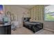 A cozy bedroom with fun decor has an attached desk, plants, and a window for natural light at 16307 29Th E Ct, Parrish, FL 34219