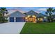 Charming single-Gathering home features a three-car garage, lush green lawn, and mature palm trees at 16307 29Th E Ct, Parrish, FL 34219