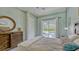 A beautifully decorated main bedroom with a view of the pool and lanai through sliding glass doors at 16307 29Th E Ct, Parrish, FL 34219