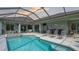 The screened-in pool area features a spa, lounge chairs, and a view of the house at 16307 29Th E Ct, Parrish, FL 34219