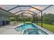 The screened-in pool area features a spa, lounge chairs, and a view of the backyard at 16307 29Th E Ct, Parrish, FL 34219
