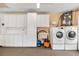 Laundry room with washer, dryer, cabinets, and utility sink at 1670 Oak View Dr, Sarasota, FL 34232