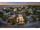 Aerial view of a waterfront home at sunset, showcasing the property and surrounding neighborhood at 201 N Harbor Dr, Holmes Beach, FL 34217