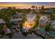 Aerial view of a modern waterfront home with a boat dock and pool at sunset at 201 N Harbor Dr, Holmes Beach, FL 34217