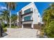 Modern two-story home with a brown garage door and a paved driveway at 201 N Harbor Dr, Holmes Beach, FL 34217