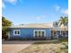 Charming blue house with metal roof, paved driveway, and nicely landscaped at 215 75Th St, Holmes Beach, FL 34217