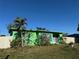 Green house with a yard and white fence at 22146 Catherine Ave, Port Charlotte, FL 33952