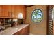 Elegant bar area with sleek wood cabinets, granite countertops, and a unique oval window at 279 Robin Dr, Sarasota, FL 34236